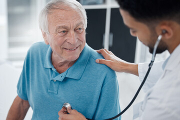 Your heart sounds strong. Shot of a young doctor examining a mature man with a stethoscope in an...