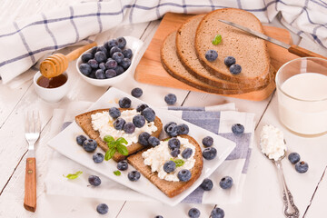 Rye bread with cottage cheese, blueberries and honey.