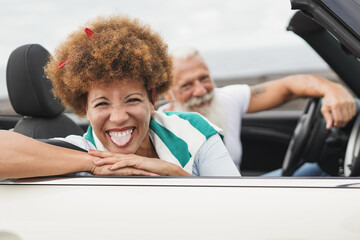 Happy senior couple having fun during road trip with cabriolet car