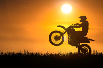 Fototapeta na wymiar Silhouette of a motocross motorcycle lifting the front wheel. Adventure and Action Concepts