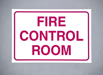 Fire Control Room Sign with red letters on white background  on outside grey metal door - Closeup