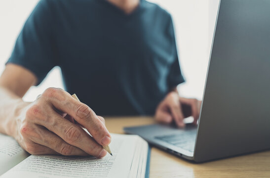 University or college student using laptop for studying, learning or reading textbook online at home. Success idea of self learning and training. Education development or knowledge improvement concept