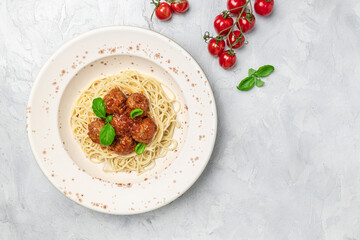 Meatballs served over italian spaghetti pasta with tomato sauce on a light background. Italian food. banner, menu, recipe place for text, top view