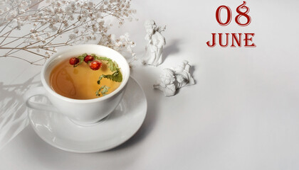 calendar date on light background with a porcelain cup of green tea, white gypsophila and angels with copy space. June 8 is the eighth day of the month