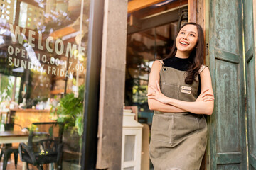 portrait of asian adult female woman wear apron standing at entrance of her workshop pottery studio...