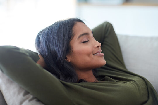 Getting a little rest. Shot of an attractive young woman relaxing on her sofa at home.