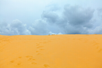 Clouds over desert . Duna with golden sand 