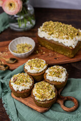 Pistazienkuchen und Cupcakes mit Frosting, Kaffeetisch Frühling mit Kuchen und Blumenstrauß