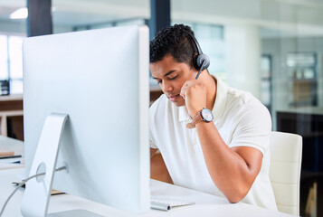 I can hear your clearly, sir. Shot of a handsome young businessman sitting alone in his office and wearing a headset while using his computer.