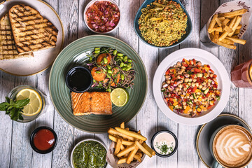 Assorted food set on table, Salmon with broccoli, salad, club sandwich, salad with quinoa, tartar from beef