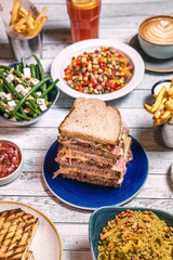 Assorted food set on table, Salmon with broccoli, salad, club sandwich, salad with quinoa, tartar from beef
