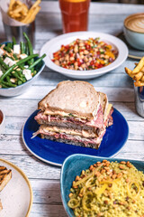 Assorted food set on table, Salmon with broccoli, salad, club sandwich, salad with quinoa, tartar from beef