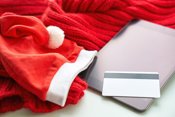 Plastic credit card mockup and tablet. Color red and white background. Atm empty debit payment. Currency shopping with stripe. Christmas hat. new year concept