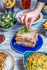 Assorted food set on table, Salmon with broccoli, salad, club sandwich, salad with quinoa, tartar from beef