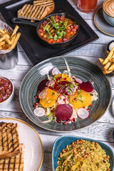 Assorted food set on table, Salmon with broccoli, salad, club sandwich, salad with quinoa, tartar from beef