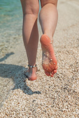 woman legs barefoot walking by sea beach