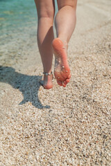 woman legs barefoot walking by sea beach