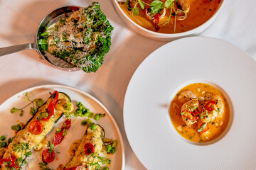 Assorted view of dinner table with delicious food set  for two, seafood,Salmon with broccoli, salad, club sandwich, salad with quinoa, tartar from beef