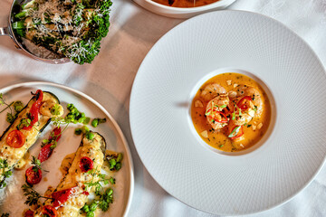 Assorted view of dinner table with delicious food set  for two, seafood,Salmon with broccoli, salad, club sandwich, salad with quinoa, tartar from beef