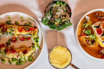 Assorted view of dinner table with delicious food set  for two, seafood,Salmon with broccoli, salad, club sandwich, salad with quinoa, tartar from beef