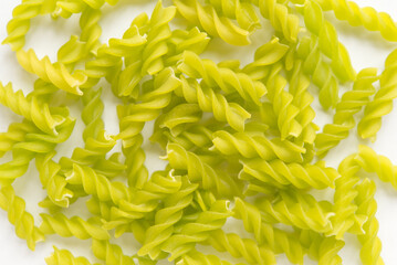 Close-up background of Fusille and Rotini in a glass bowl on white. pasta colorata