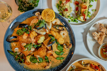 Assorted view of dinner table with delicious food set  for two, seafood,Salmon with broccoli, salad, club sandwich, salad with quinoa, tartar from beef