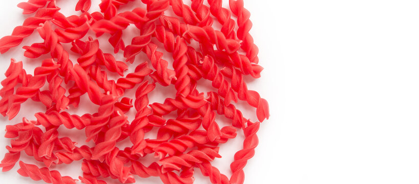 Close-up background of Fusille and Rotini in a glass bowl on white. pasta colorata