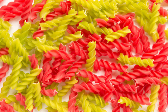 Close-up background of Fusille and Rotini in a glass bowl on white. pasta colorata