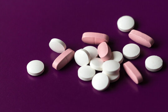 Different pills on the purple background. Selective focus, shallow depth of field