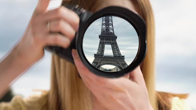 Dream trip to Paris. A girl takes pictures of the Eiffel Tower. Eiffel tower reflection in camera lens