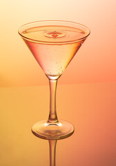 The glass with dripping liquid on the orange background