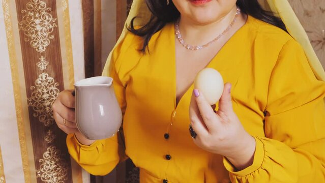A Jewish woman holds an egg and a pitcher of salt water in her hand to fulfill the commandment on Pesach. Overall plan