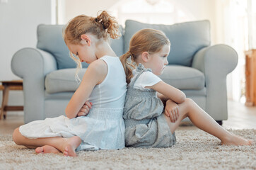 Im going to tell mom. Shot of two little girls sitting back to back and looking angry at home.