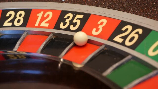 Ball on wooden french roulette table in casino. Wheel spinning, turning or rotating. Odd and even numbers, black, red and zero sectors. Bets in game of chance. Money playing, gambling or risky betting