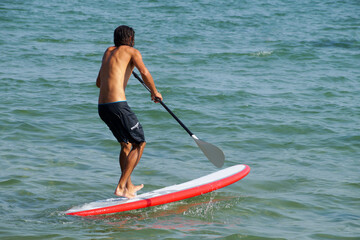 man with a paddle on a SUP board in the sea