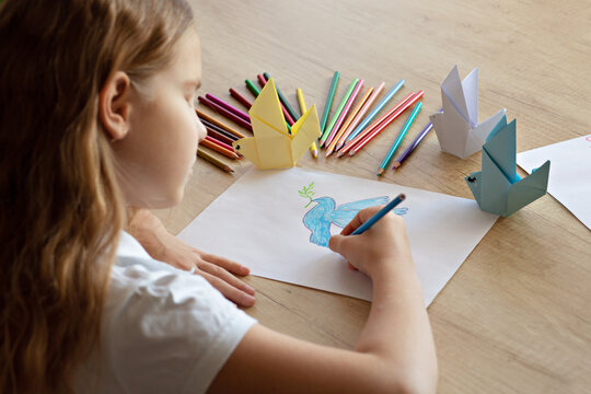 Girl drawing a dove of peace Save our planet. The concept of art training and education, love for the earth, saving the world and unity. The concept of ecology and against war. selective focus