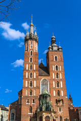 Fototapeta na wymiar Basilica of Holy Mary on the main market square of Krakow Sunny day with a spring tree branch in the foreground