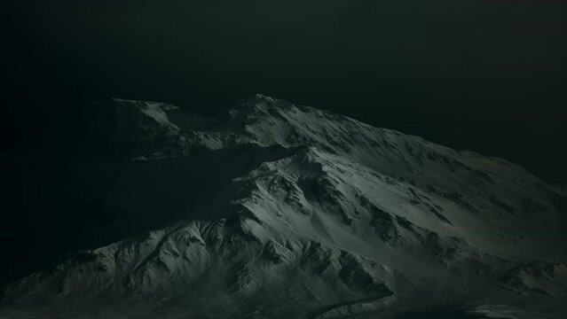 Dramatic dark rocky mountain with patches of snow in storm