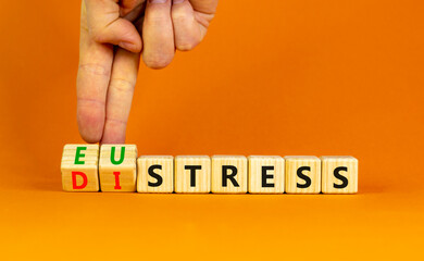 Eustress or distress symbol. Psychologist turns cubes and changes the concept word Eustress to Distress. Beautiful orange table orange background, copy space. Psychlogical distress eustress concept.