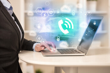 Hands working on laptop with digital icons