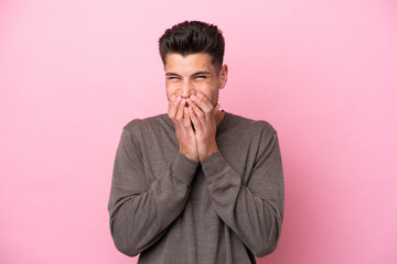 Young caucasian man isolated on pink background happy and smiling covering mouth with hands