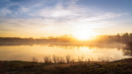 Sunrise at the Illingen quarry pond on a cold foggy morning