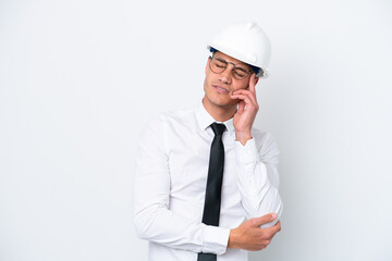 Young architect caucasian man with helmet and holding blueprints isolated on white background with headache