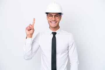 Young architect caucasian man with helmet and holding blueprints isolated on white background showing and lifting a finger in sign of the best