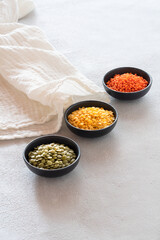 Composition with bowl of lentils. Red, yellow and green lentils on a bright background. Minimal kitchen scene. 