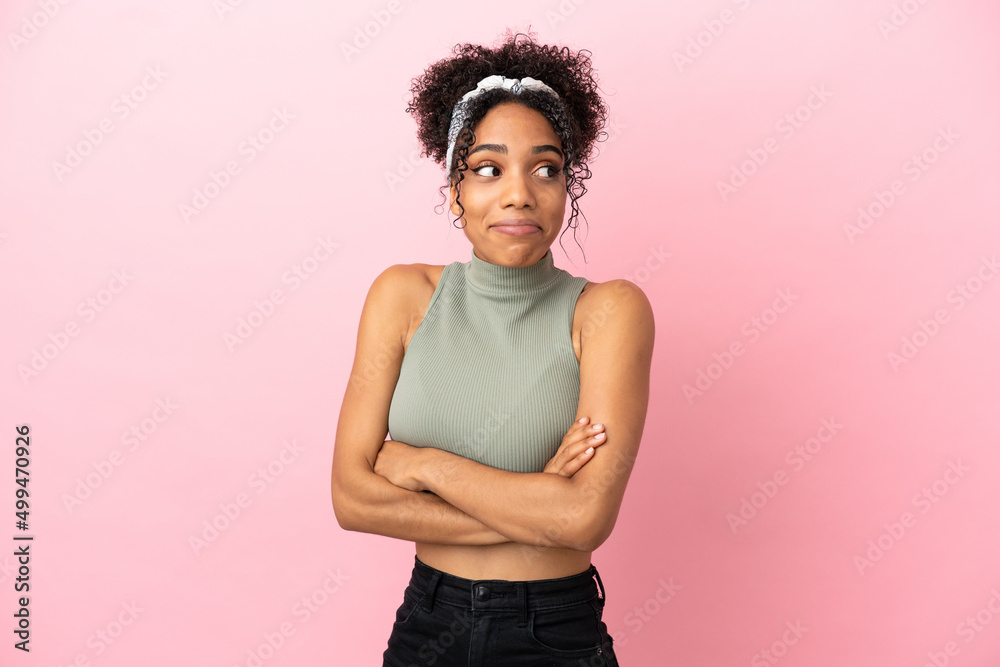 Sticker Young latin woman isolated on pink background making doubts gesture while lifting the shoulders