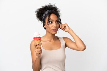 Young african american woman with a cornet ice cream isolated on white background having doubts and...