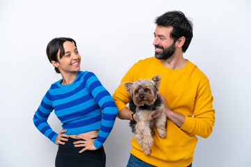 Young hispanic woman holding a dog isolated on white background happy and smiling