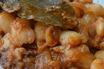 cooked beans with red pepper sauce and bay leaf
