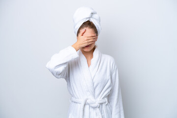 Teenager Russian girl in a bathrobe isolated on white background covering eyes by hands. Do not want to see something